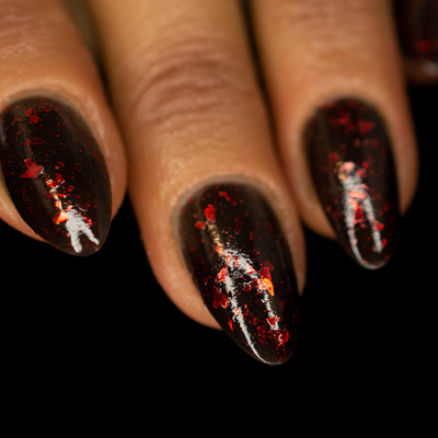 A close-up image of a fingernail painted with a black jelly base nail polish, featuring striking red metallic flakes and delicate red micro flakes.