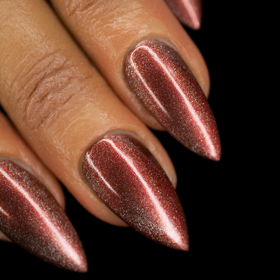 A close-up image of fingernails painted with a deep red glittery nail polish, showing the magnetic effect and the shiny, glittery finish.