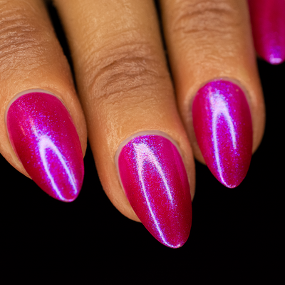 A close-up image of almond shaped fingernails painted with a vibrant magenta jelly base nail polish with a blue-purple shimmer.