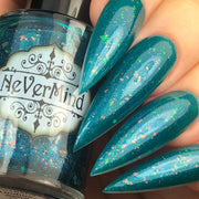 Close-up of stiletto-shaped nails painted with shimmery teal nail polish featuring multicolored flecks, holding a bottle of NeVerMind nail polish.